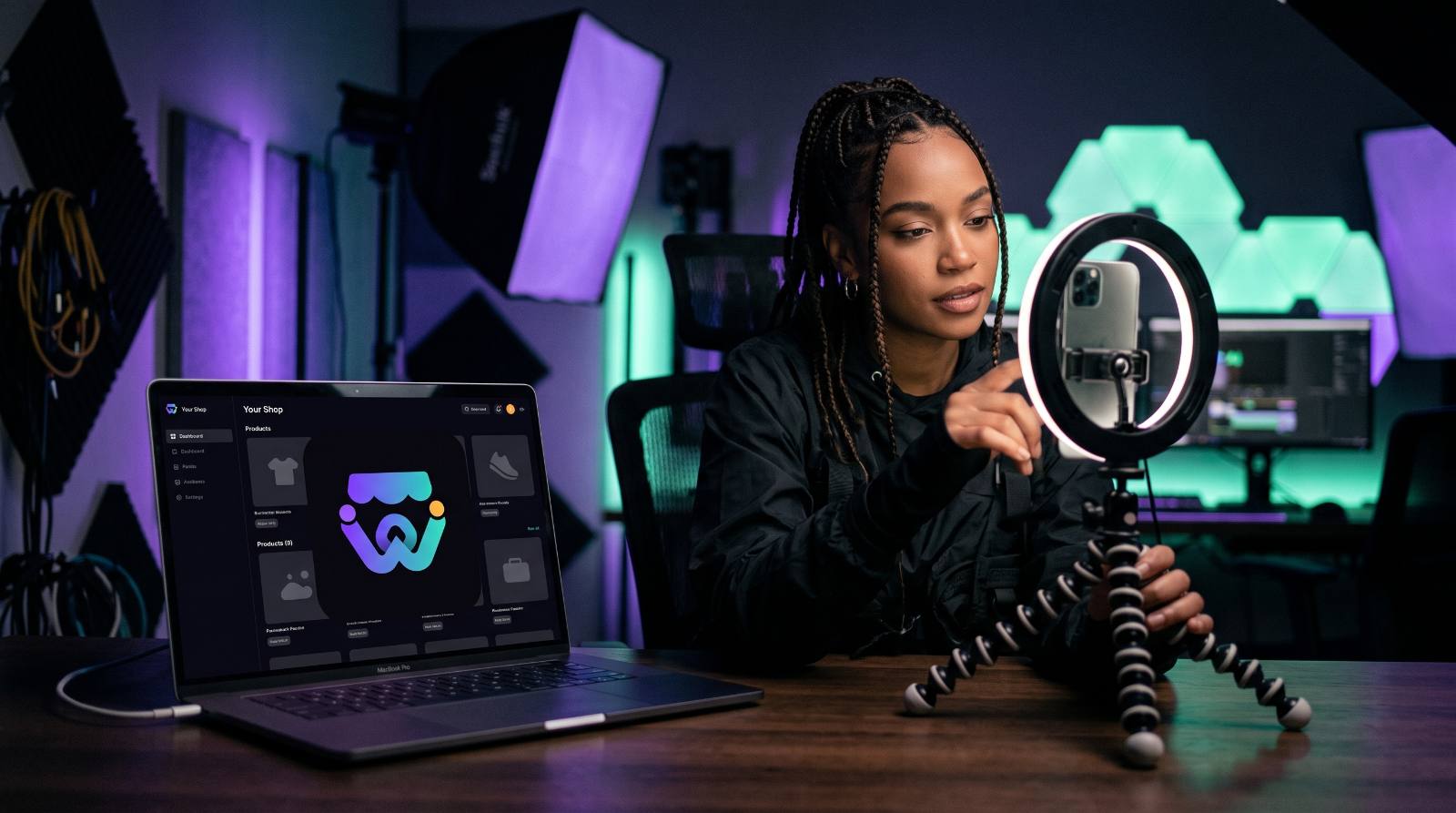 Content creator filming a video with her Weello storefront dashboard open on a laptop